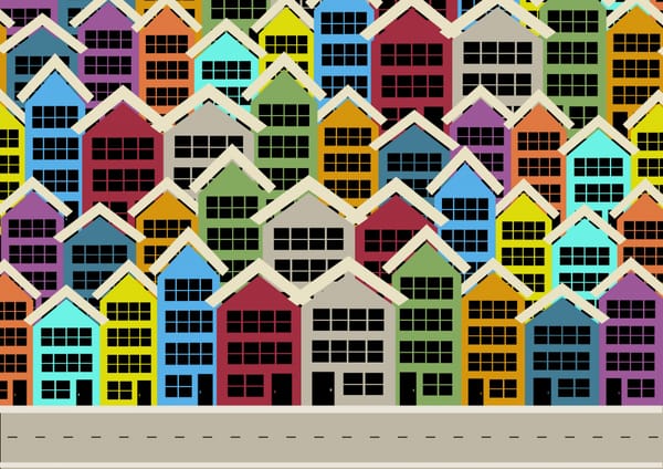 Stacked rows of multi-coloured multi-story homes with a road in the foreground.